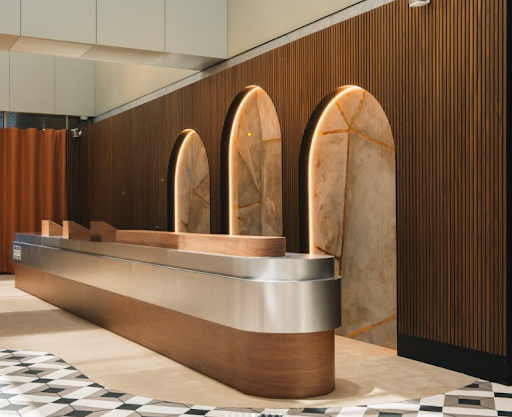 Wide view of the Club 1905 area at the Australian Open 2026, showing the curved desk and illuminated stone archways.